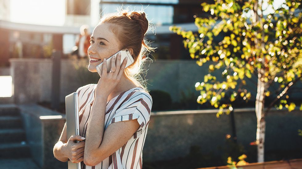 Young woman on phone conducts a job search in the summer after college