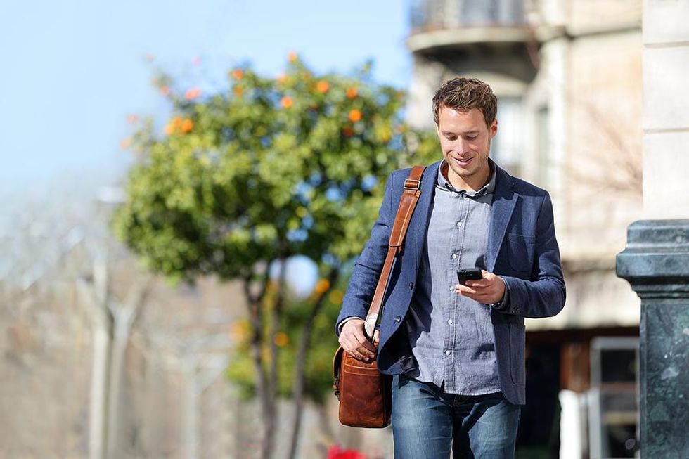 Man on phone makes plans after work in the summer