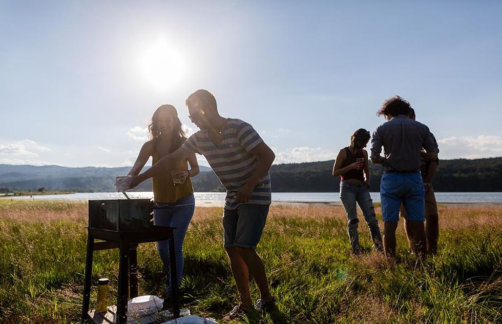 Coworkers hang out and have a barbecue after work during the summer