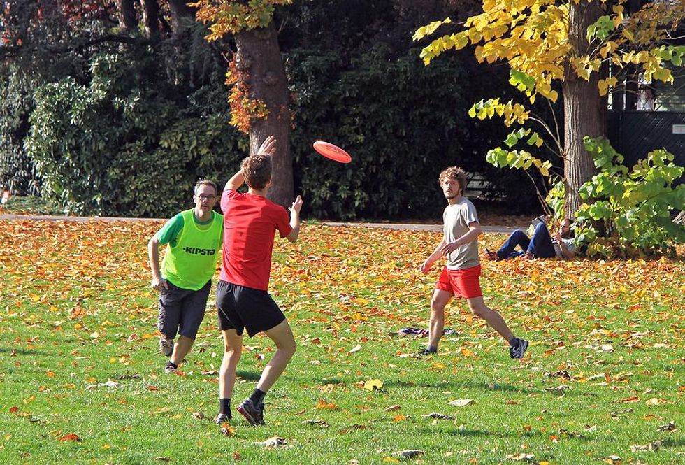 Coworkers/employees play frisbee after work in the summer to stay active