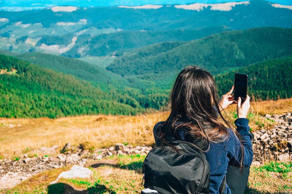 Woman on vacation takes a picture of the view