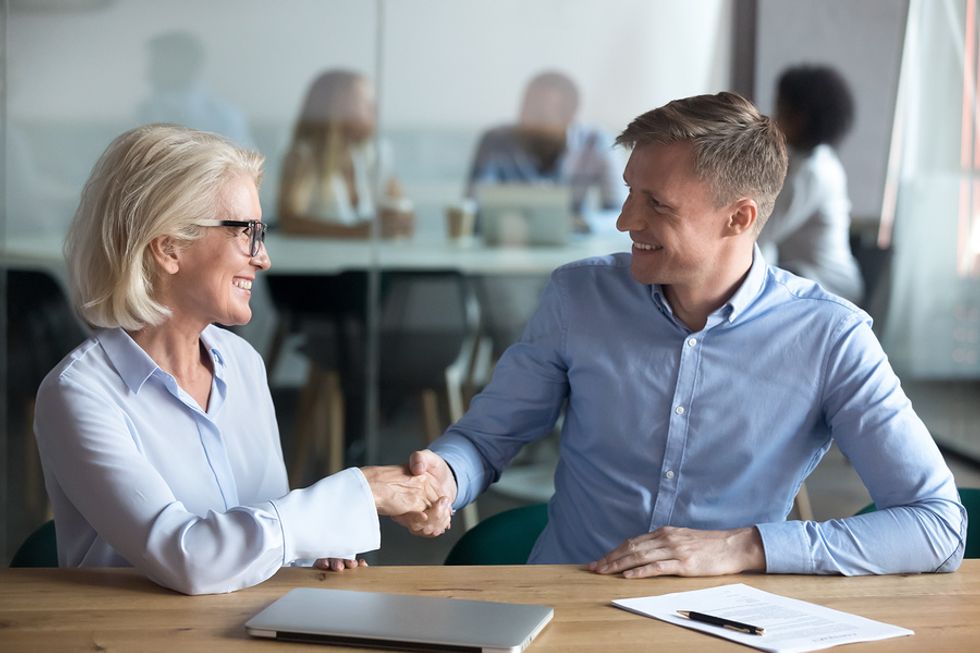 Professional man receives advice about career success from an older coworker