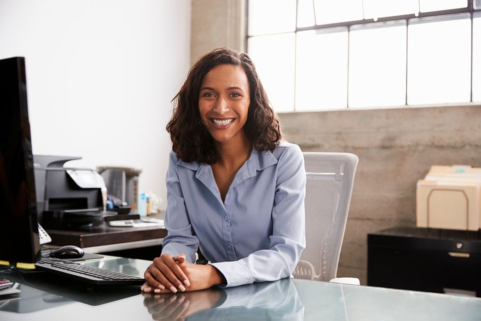 Happy professional woman at work achieves career success after being persistent