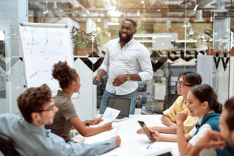 Executive effectively conveys his executive presence during a team work meeting presentation