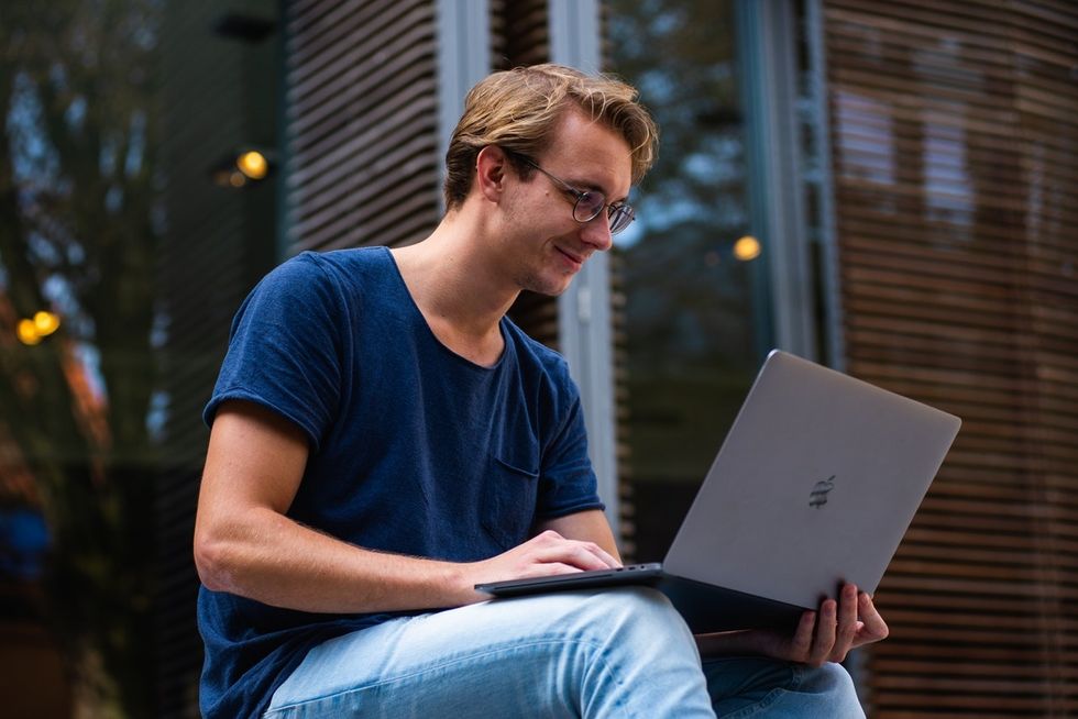 Young professional on laptop learning how to update his LinkedIn profile to help recruiters find him