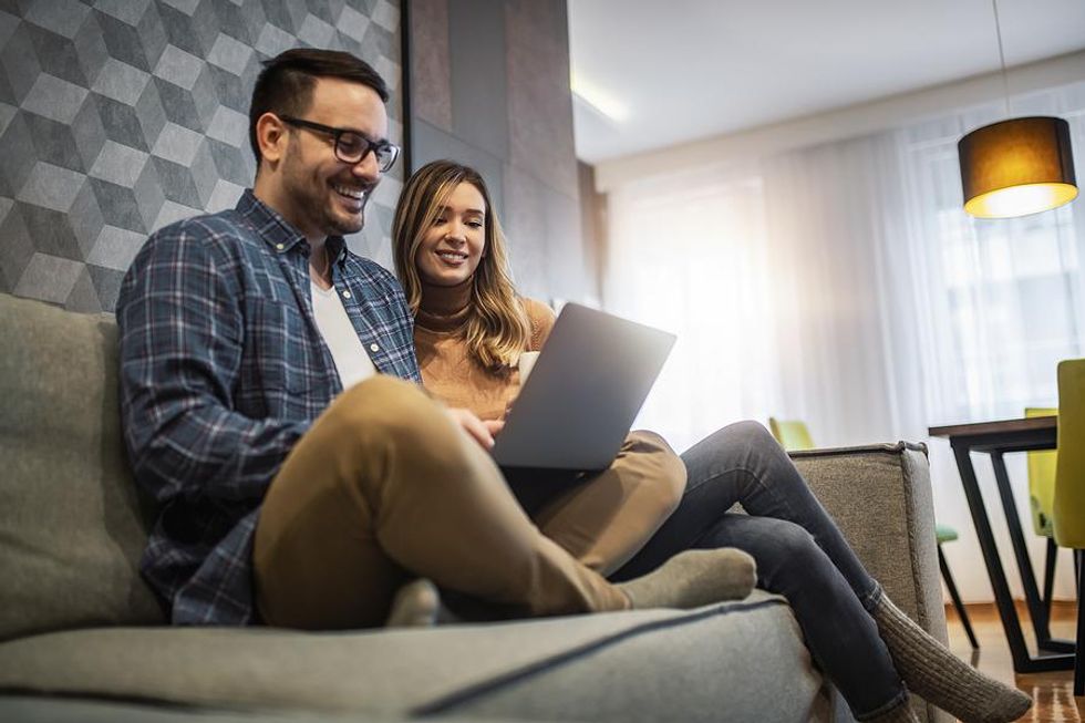 Man and woman use laptop together to make their interview bucket lists