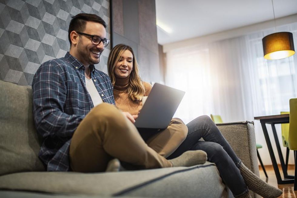 Man and woman use laptop together to make their interview bucket lists