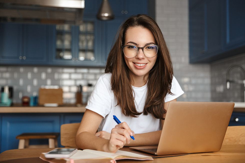 Happy woman on laptop bounces back after getting laid off