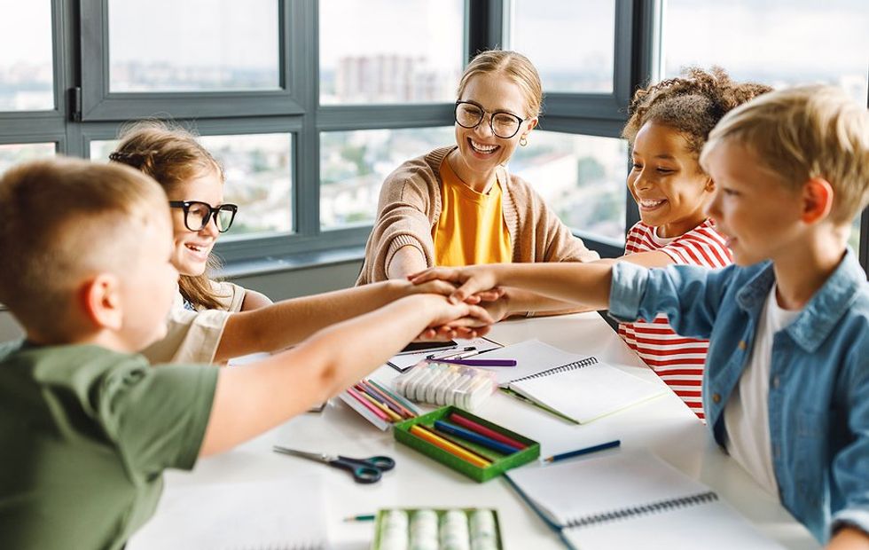 Happy students and teacher celebrate in the classroom