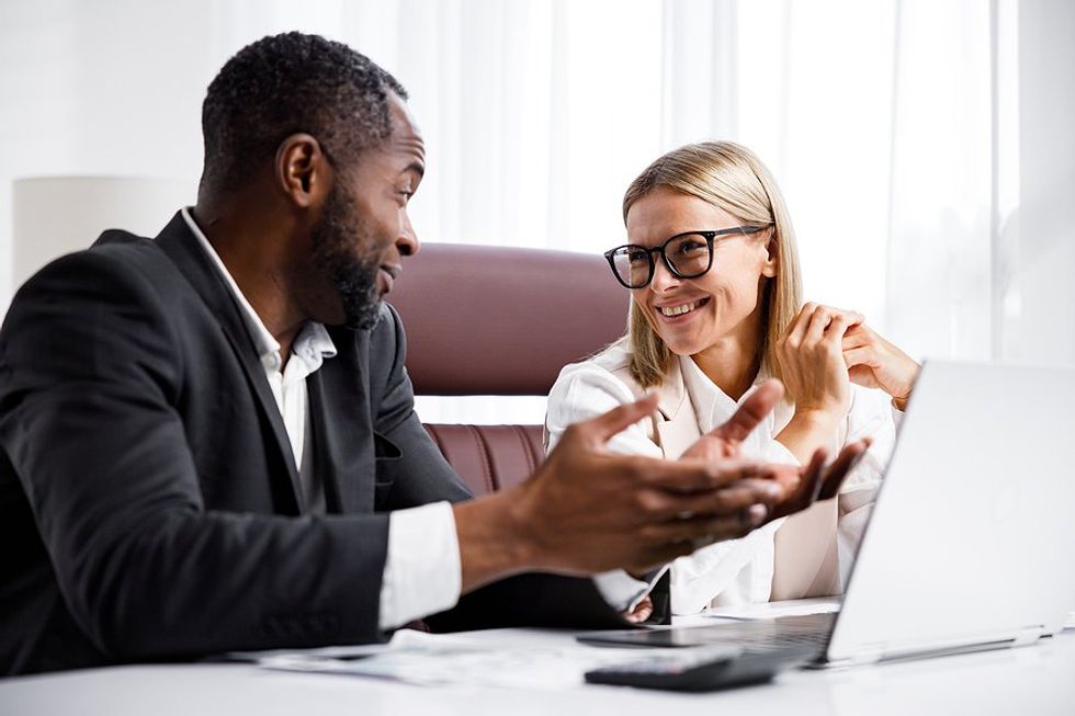 Coworkers talk while working in the office