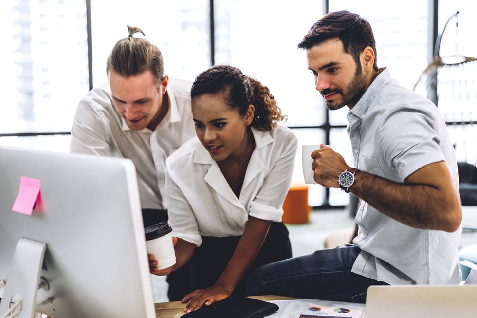 A group of coworkers work/collaborate on a work project