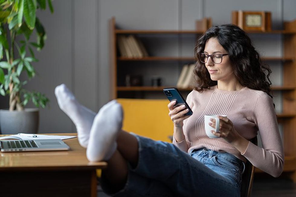 Woman sends a message to a LinkedIn connection with her phone