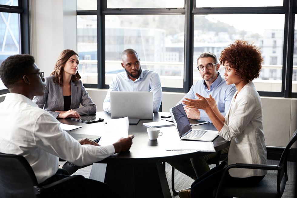 Woman sharpening her leadership skills by speaking up and sharing her opinion in an office meeting