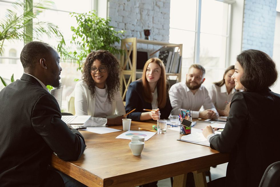 Coworkers discuss diversity and the company's role in improving society during a work meeting