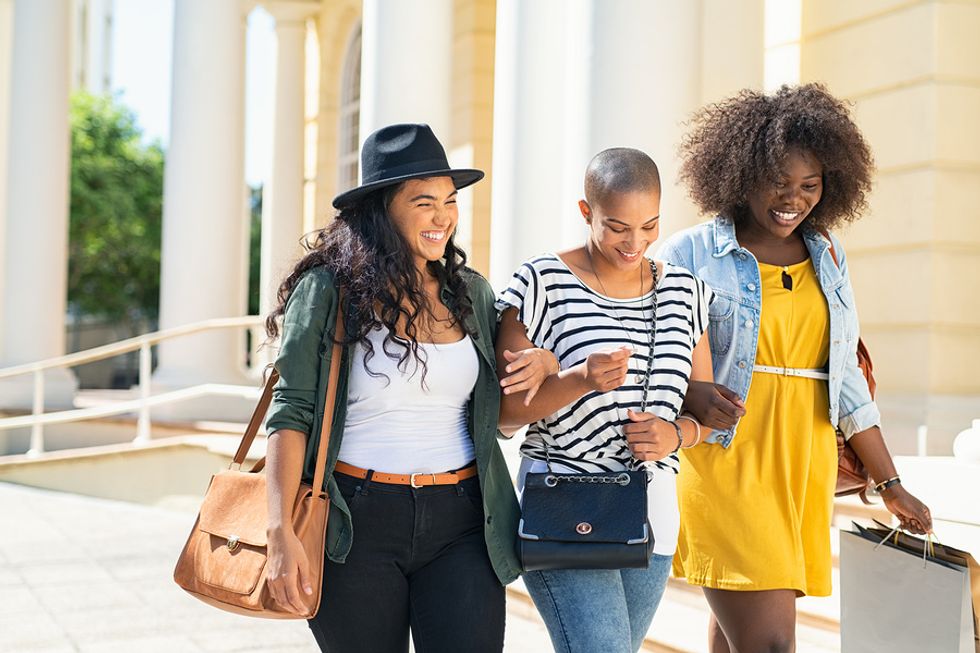 Happy professionals go shopping for new work outfits and walk together