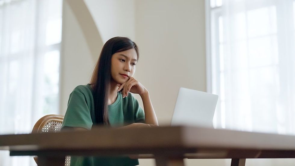 Young woman / recent college grad on laptop applies for jobs