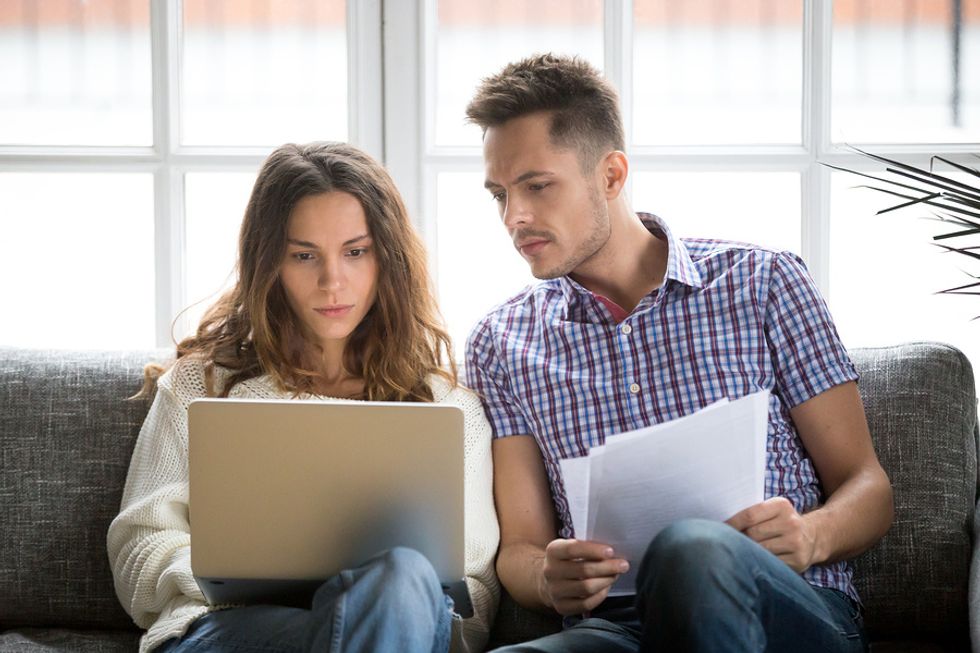 Couple on laptop work together to write a cover letter