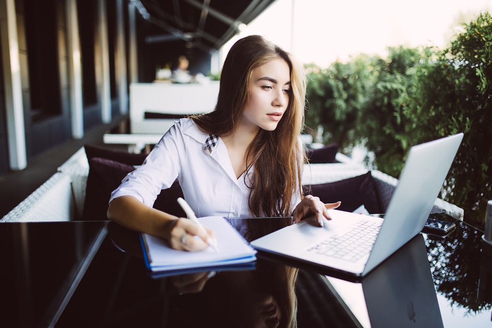 Young professional woman on laptop writing her cover letter and avoiding critical cover letter mistakes