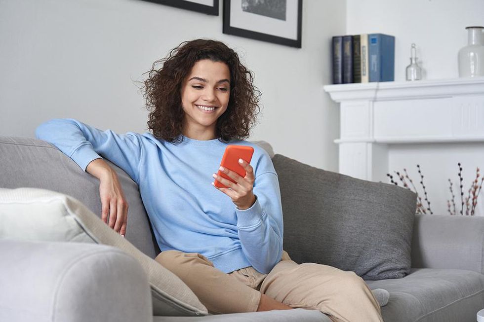 Woman on phone updates her LinkedIn profile to get noticed