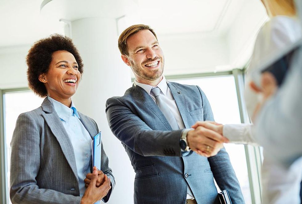 Man shakes someone's hand while networking at his new job