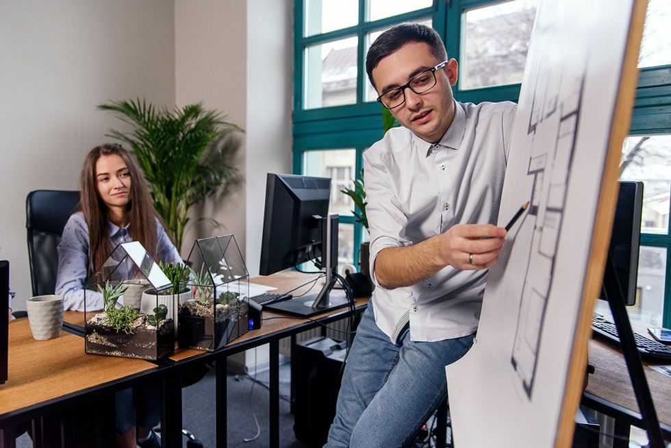 Man showing he's ready to take on more responsibility at work by leading a tough project and making a presentation