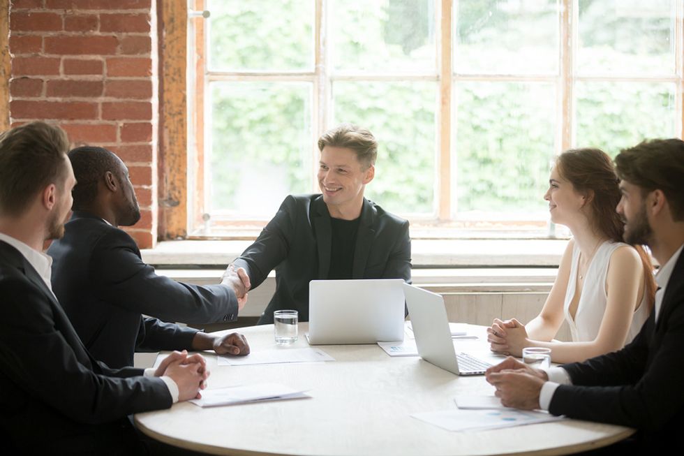 Male boss/leader seeing a win-win situation in a team meeting at work