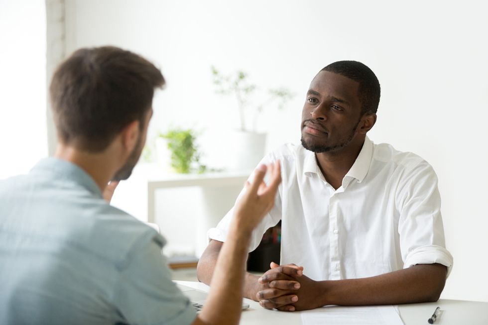 Employee receiving constructive feedback in an office and thinking about how he can develop his leadership skills