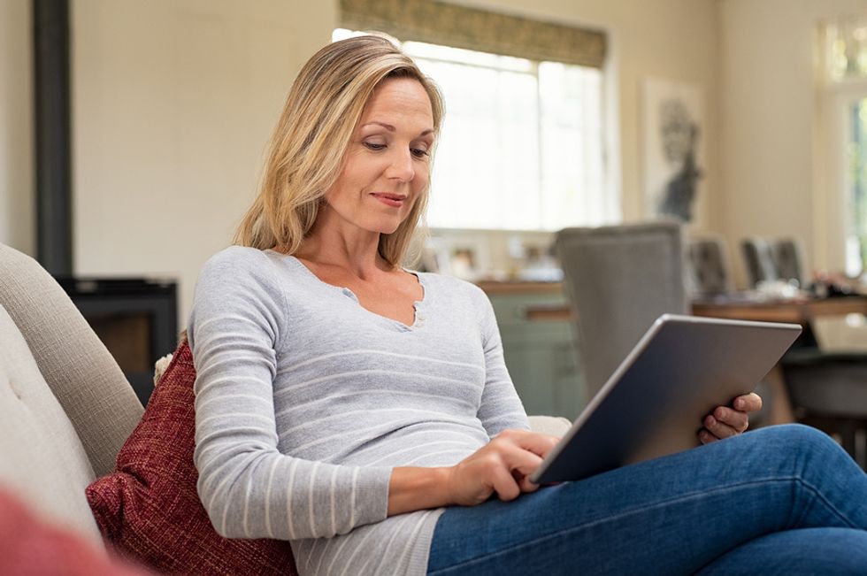 Professional woman uses tablet to read work email in an attempt to become more tech savvy