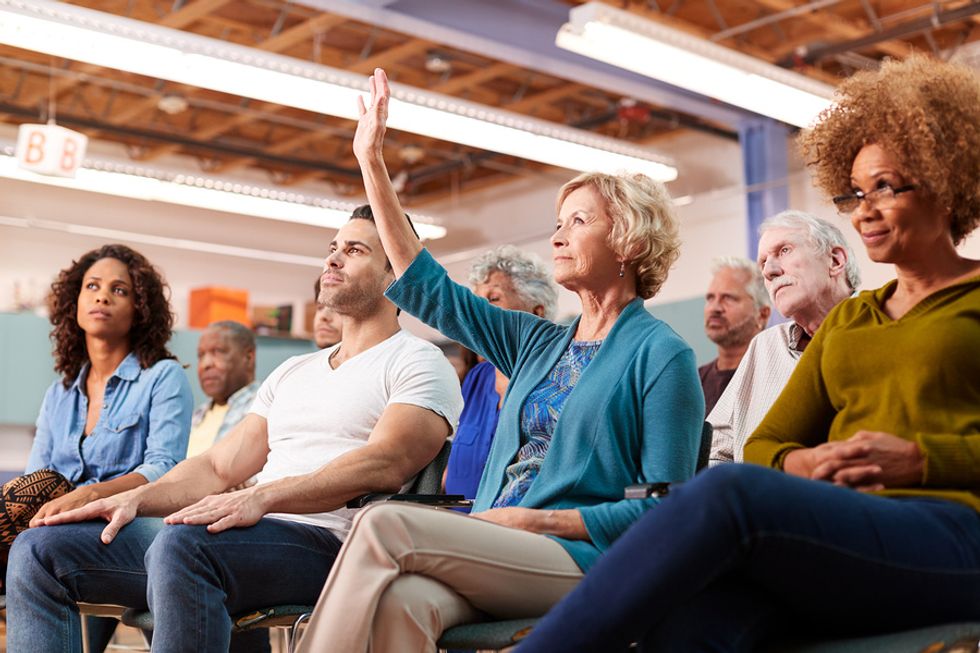 Older professional asking a question about new office technology