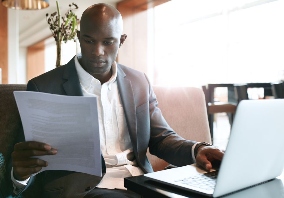 Job seeker on laptop creating a detailed executive resume