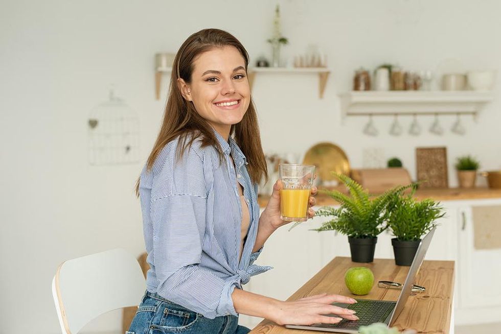 Happy woman on laptop writes a message to a hiring manager