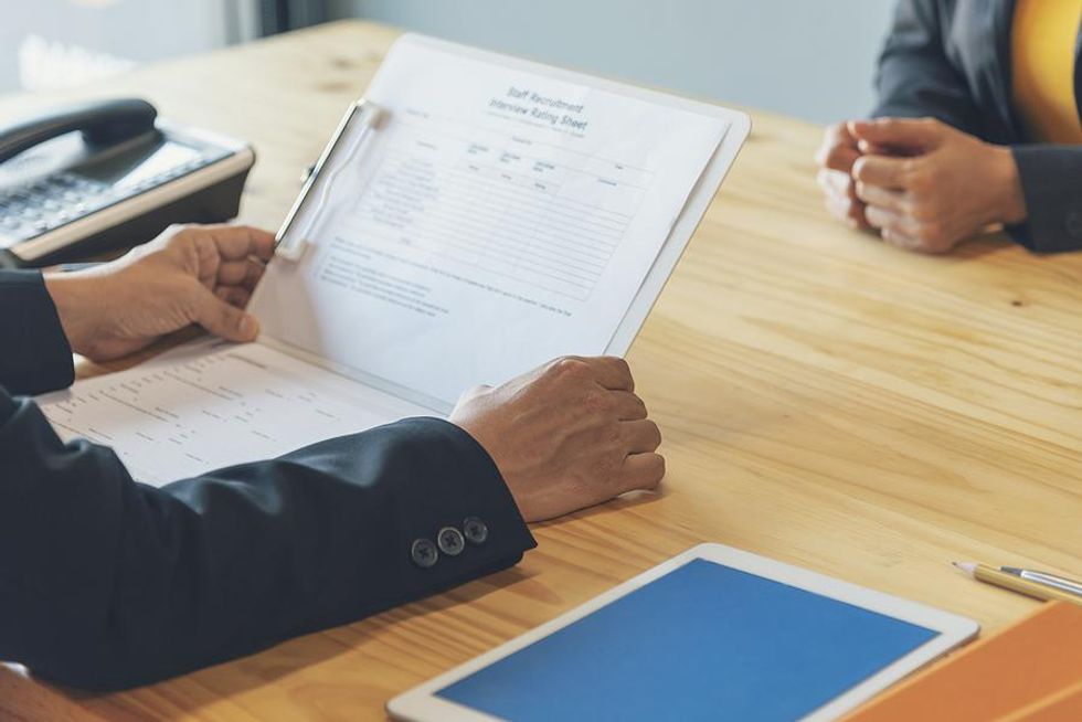 Hiring manager looks at a job candidate's resume during an interview