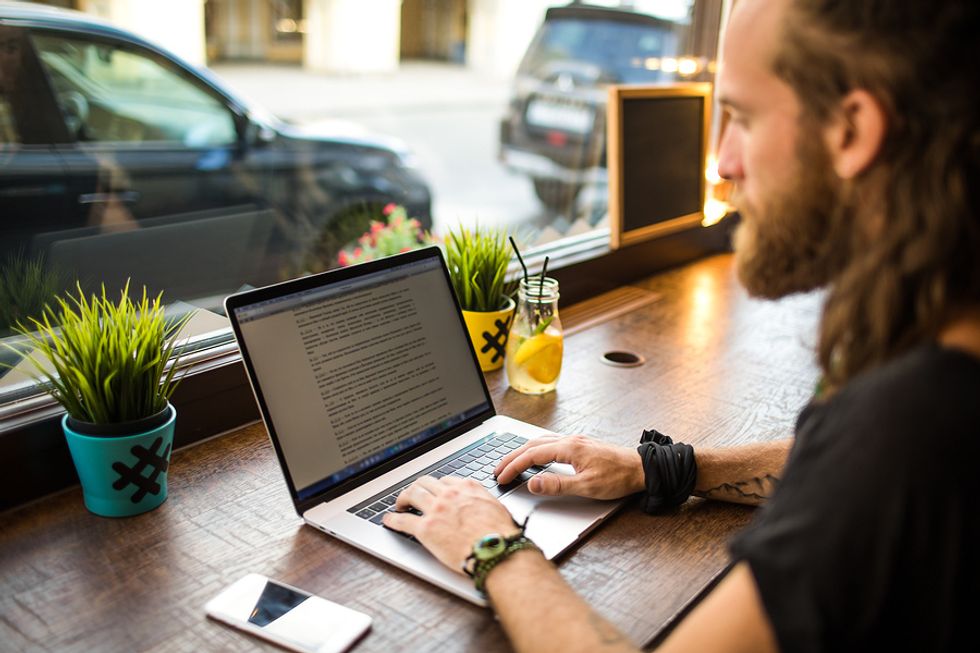 Man on laptop finds contact information to put on his resume