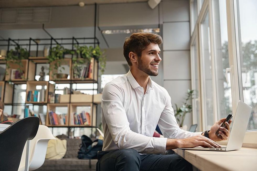 Man on phone and laptop builds his professional network