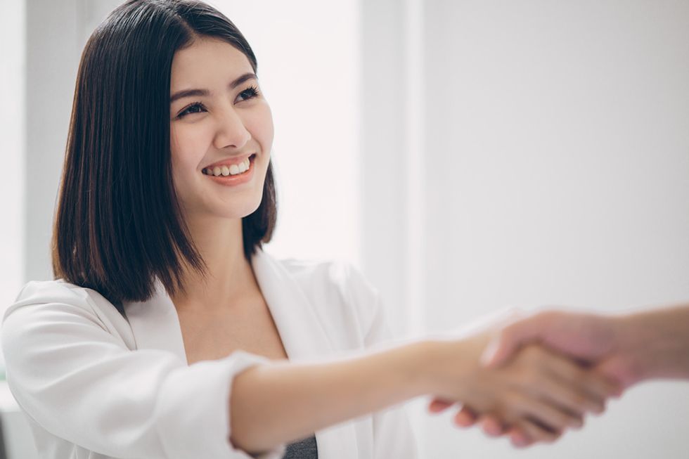 Woman shakes the hand of the hiring manger before a job interview