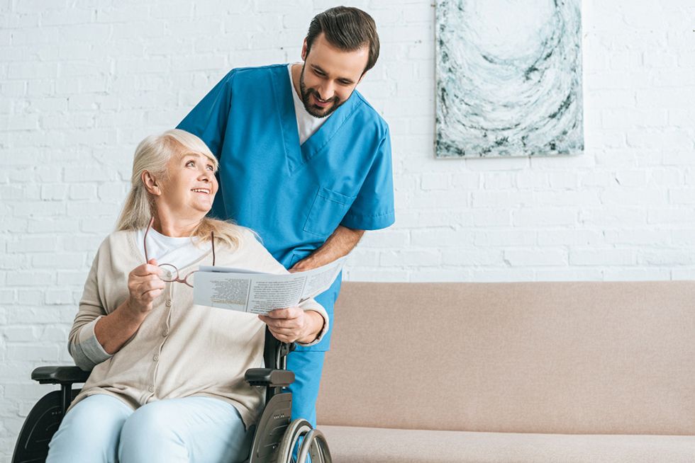 Nurse transports a patient in a wheelchair