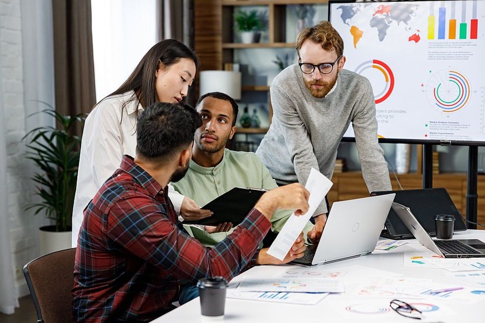 Employees/coworkers in a meeting discuss business sustainability and planning