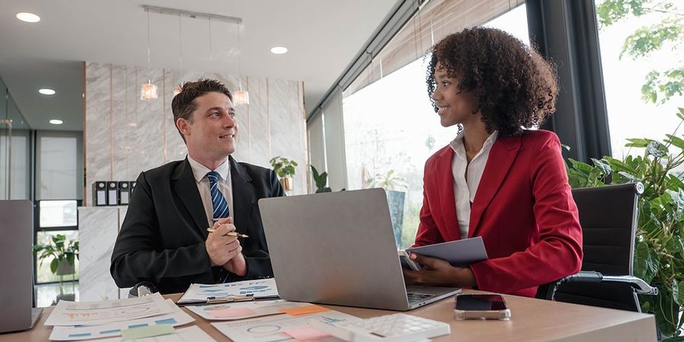 Coworkers talk about the budget during a work meeting