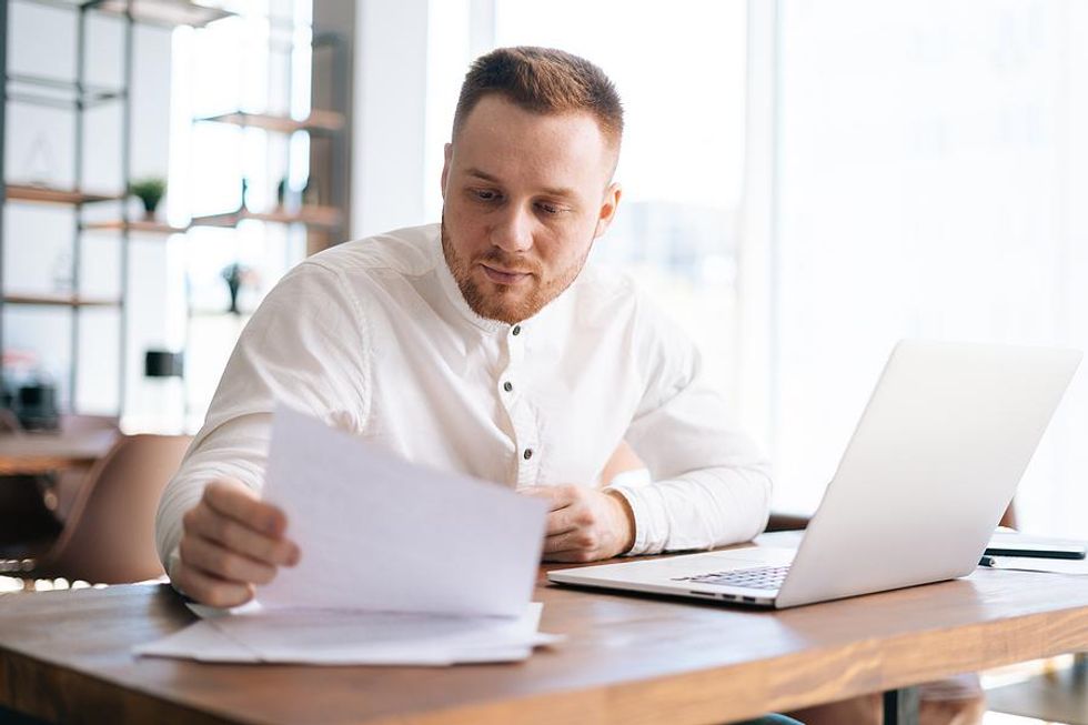 Man looks at his resume while applying for a job on his laptop