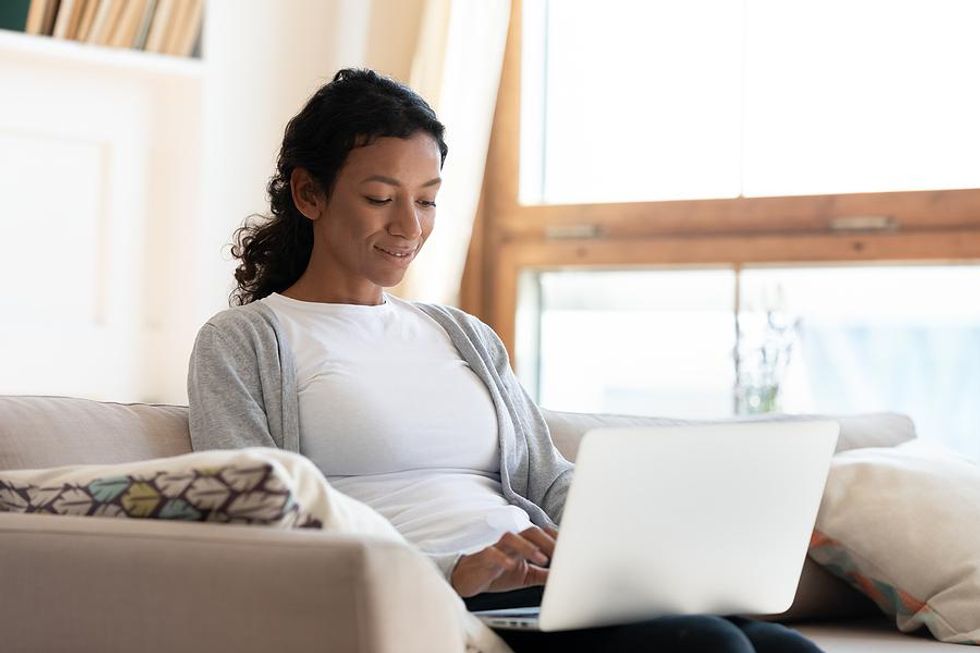 Woman on laptop updates her LinkedIn profile with achievements