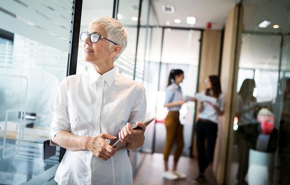 Older professional woman thinking about her career success at work