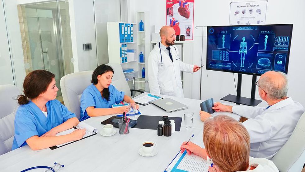 Medical assistant listens and takes notes during a meeting