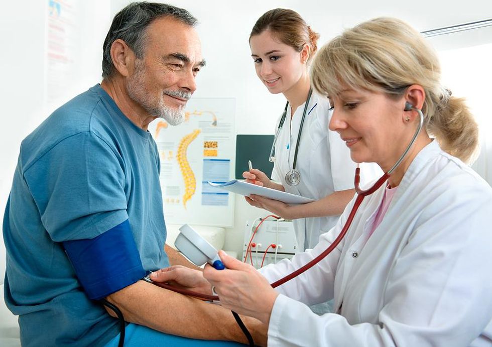 Medical assistant and nurse take care of a patient