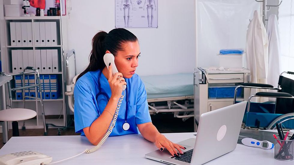 Medical assistant listens to a patient on the phone