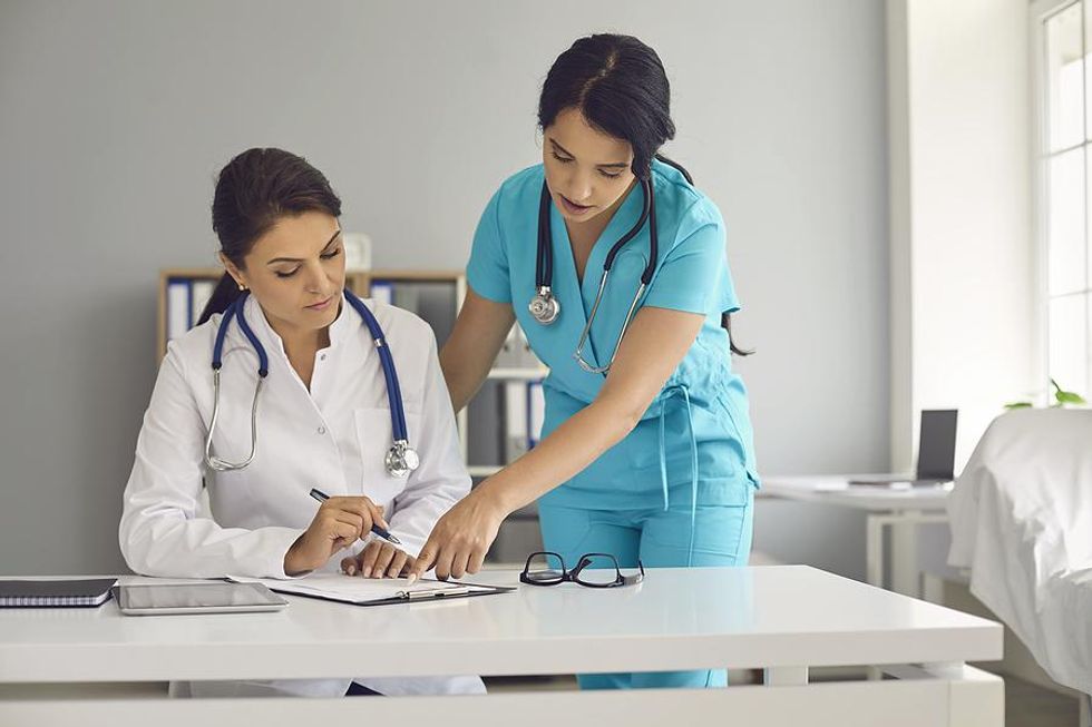 Medical assistant talks to a doctor