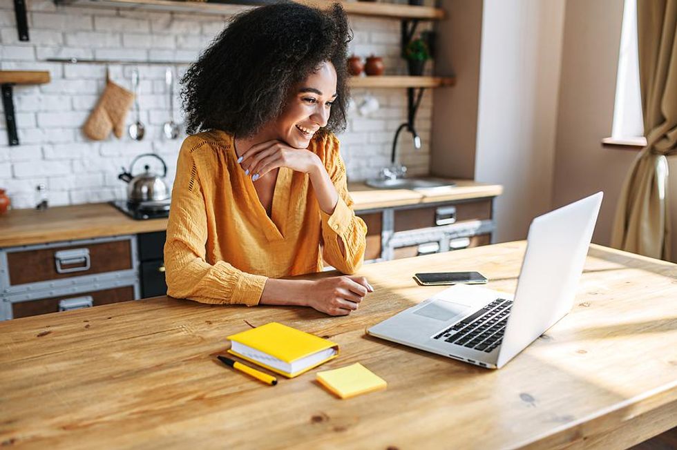 Woman on laptop smiles while working from home