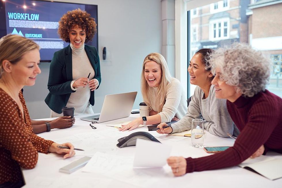 Group of happy women at work talk during a meeting