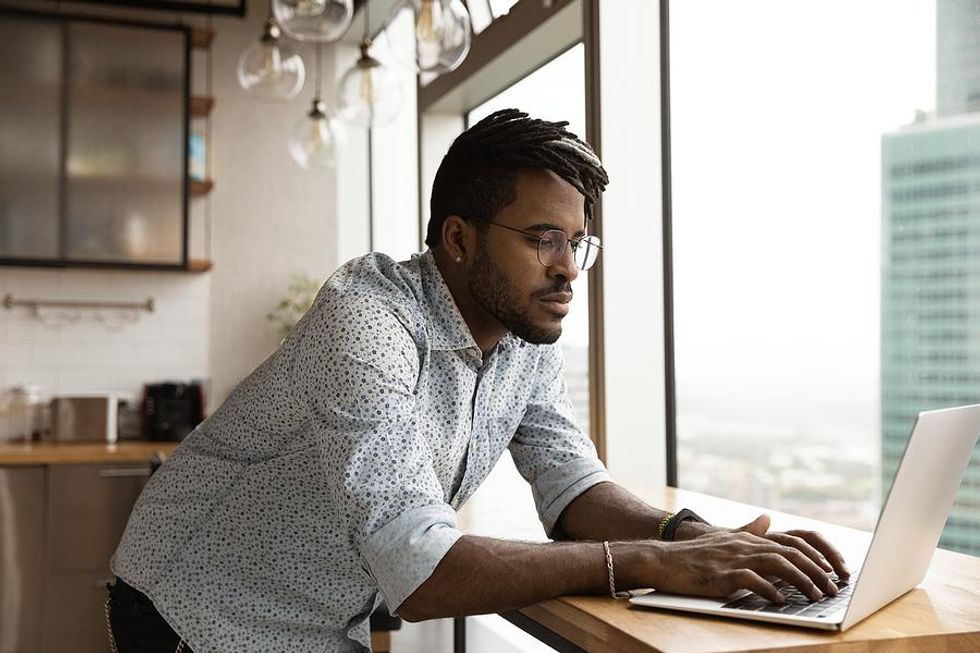 Man on laptop thinks about his career goals for the next year