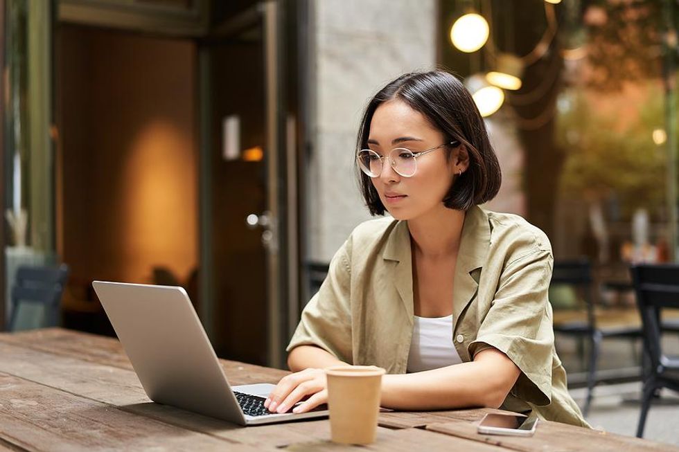 Serious woman on laptop researches a company's DE&I