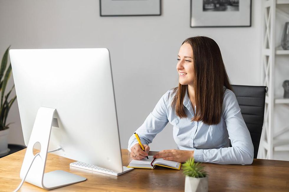 Young job seeker takes notes during her job search and adds companies to her interview bucket list